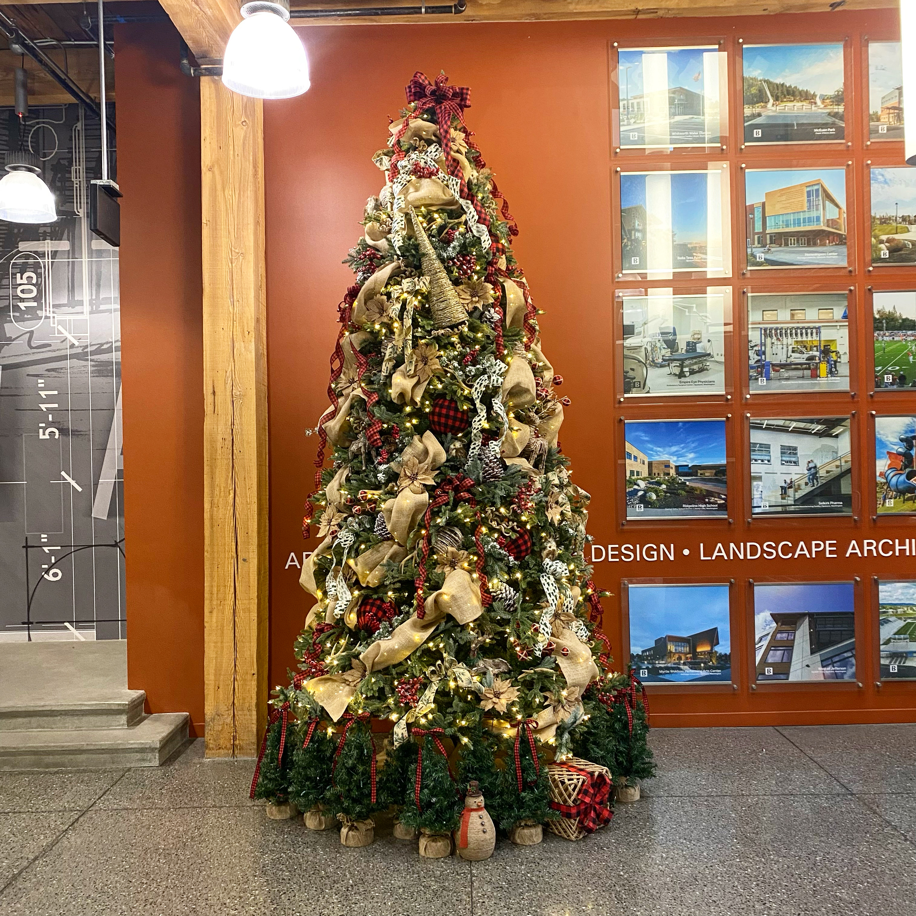 Custom Christmas tree decorated with layered ribbon, greenery, and warm lights